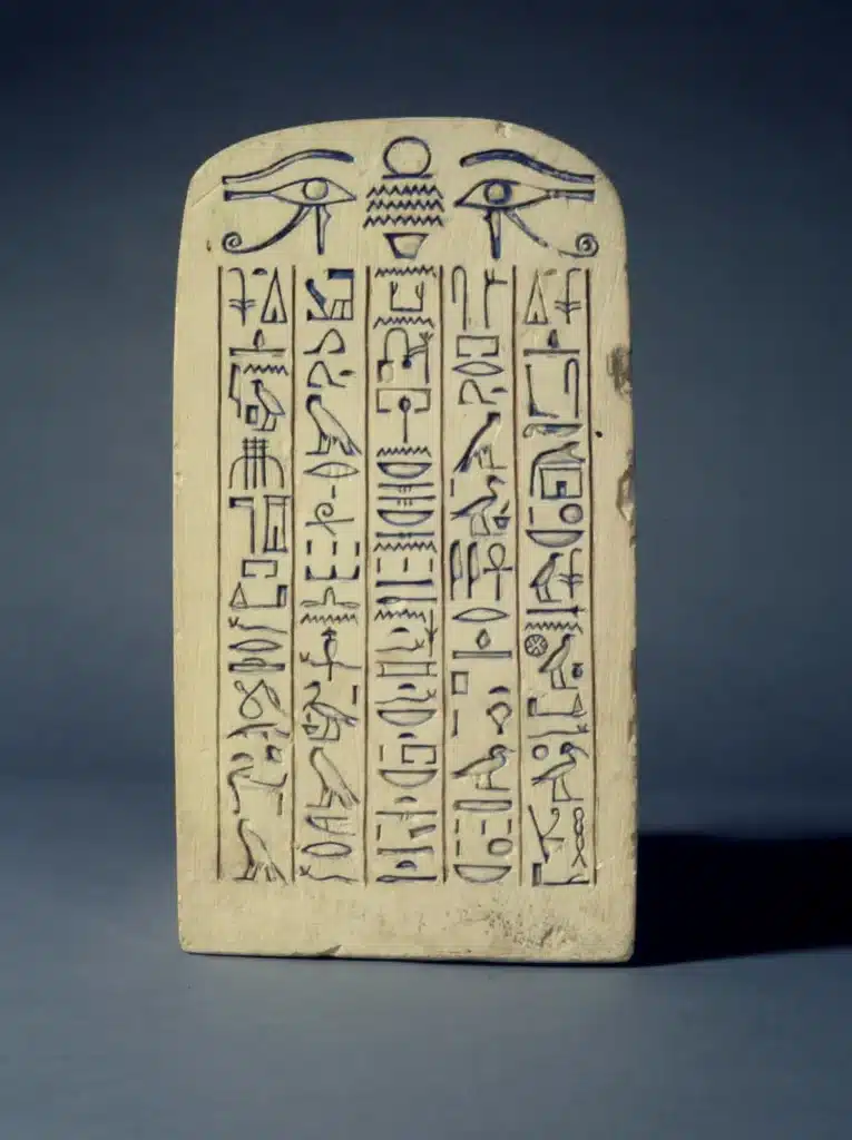 Photo du dos d'un groupe statuaire du couple Nebsen et Nebet-ta, assis. La forme de l'arri&egrave;re de la statue repr&eacute;sente une st&egrave;le cintr&eacute;e, grav&eacute;e de hi&eacute;roglyphes sur 5 colonnes.