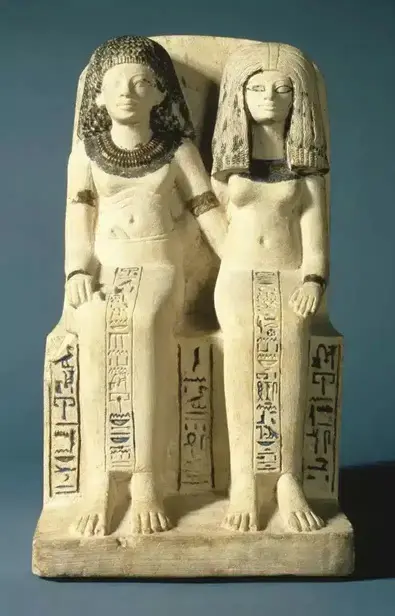 Photo de face du groupe statuaire du couple Nebsen et Nebet-ta, assis et passant chacun un bras autour de la taille de l'autre. Chaque personnage porte un pagne long, grav&eacute; de hi&eacute;roglyphes sur une colonne.